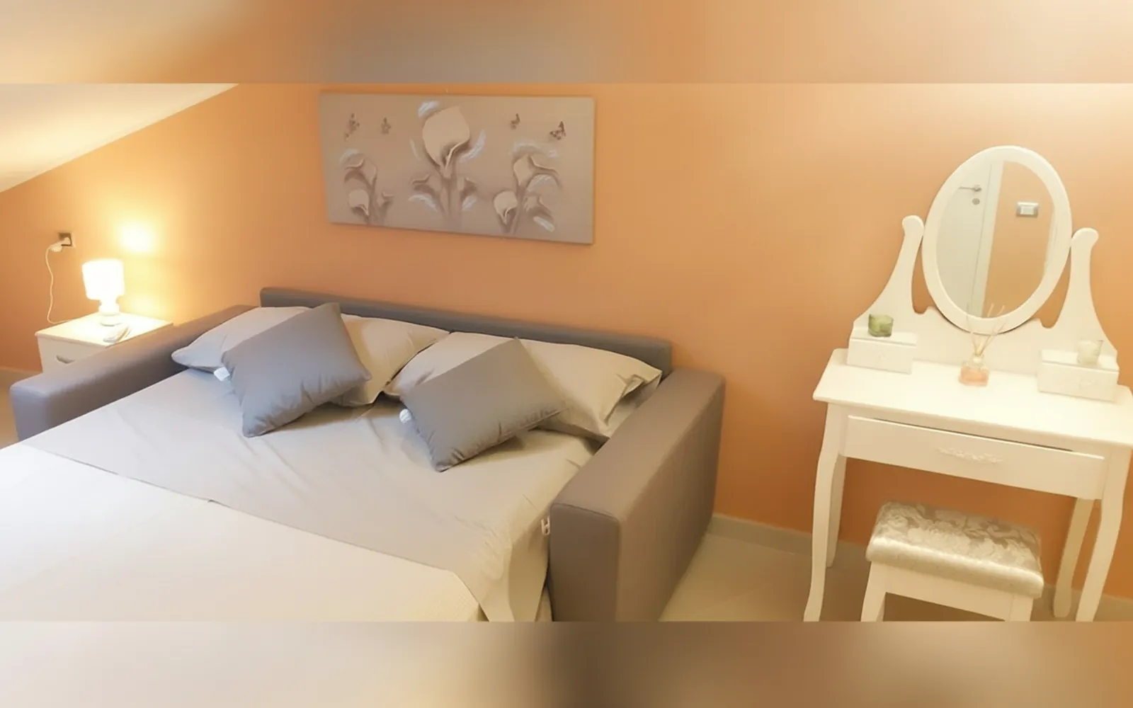 La Camera Deluxe con il letto matrimoniale e la toeletta con lo specchio ovale